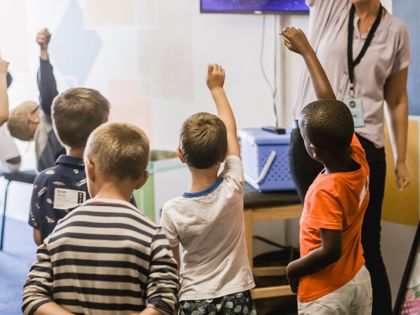 class of pupils with hands raised.jpg